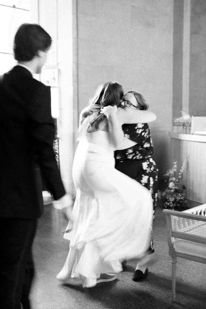 bride hugging her Maryland wedding planner at her reception at the Baltimore Museum of Art