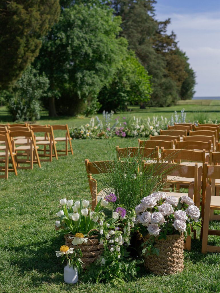 baskets of flowers decorating the back of the aisle for an Annapolis waterfront wedding ceremony at Whitehall